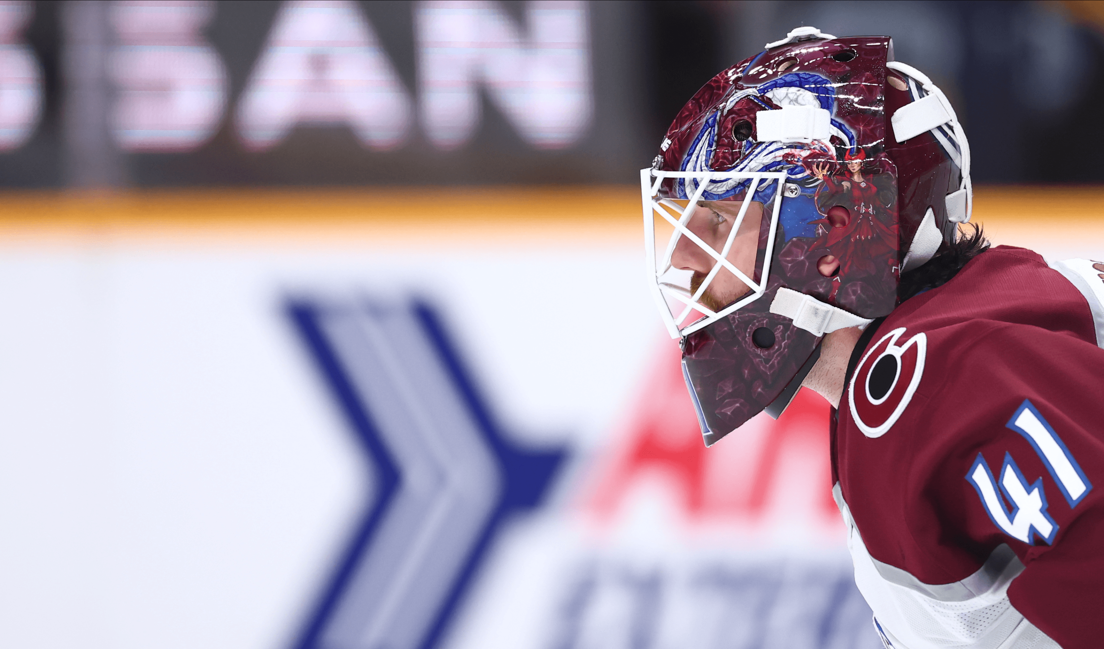 Hockey goalie in maroon jersey #41 wearing a custom mask.